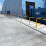Industrial warehouse with yellow safety railings and recycling compactor