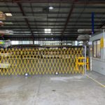 Interior of a warehouse with yellow safety barrier.
