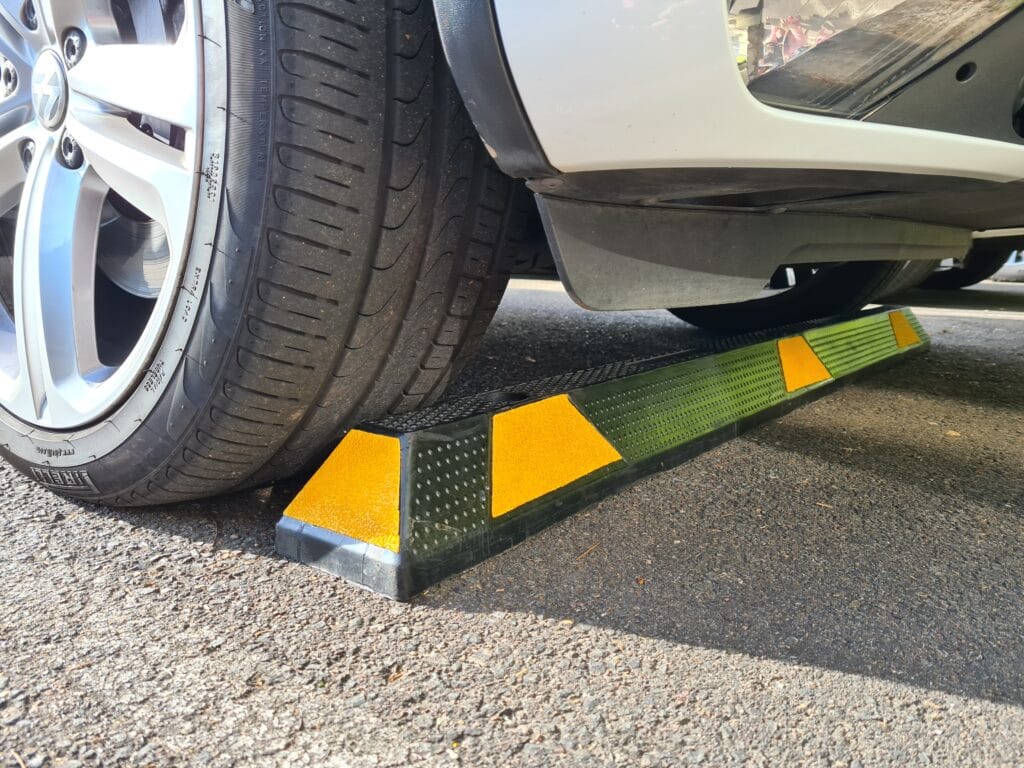 Car tire resting on a parking curb.