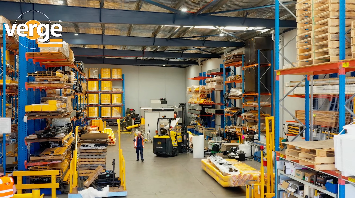 Spacious warehouse with shelves and machinery.