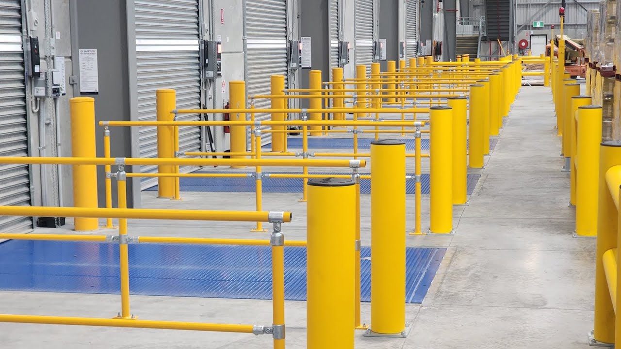 Industrial space with yellow safety barriers and markings.
