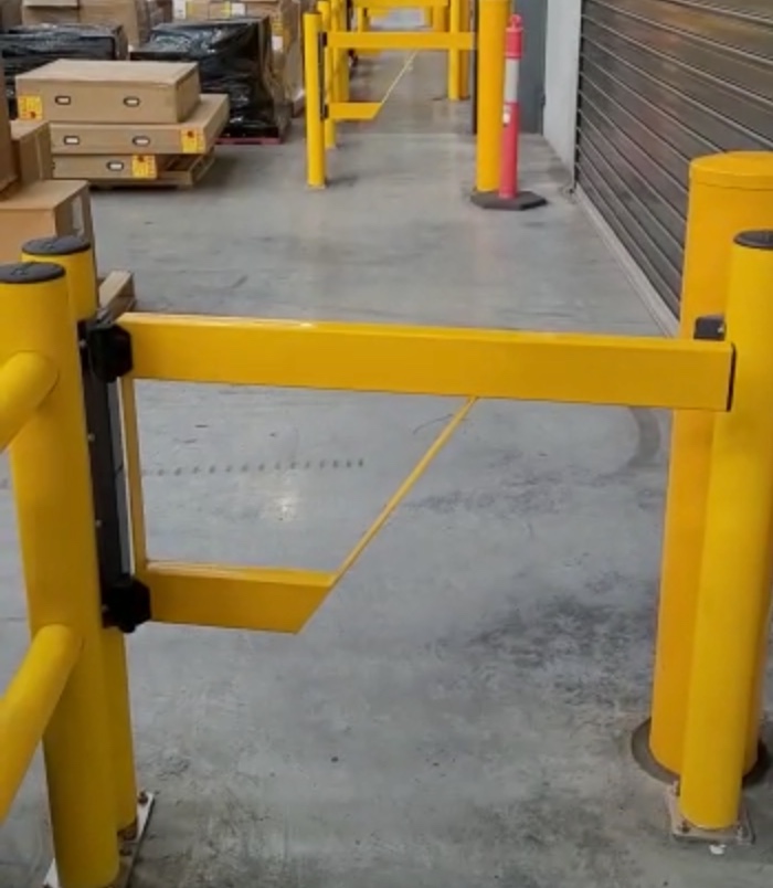 Yellow barrier gate in a warehouse environment.
