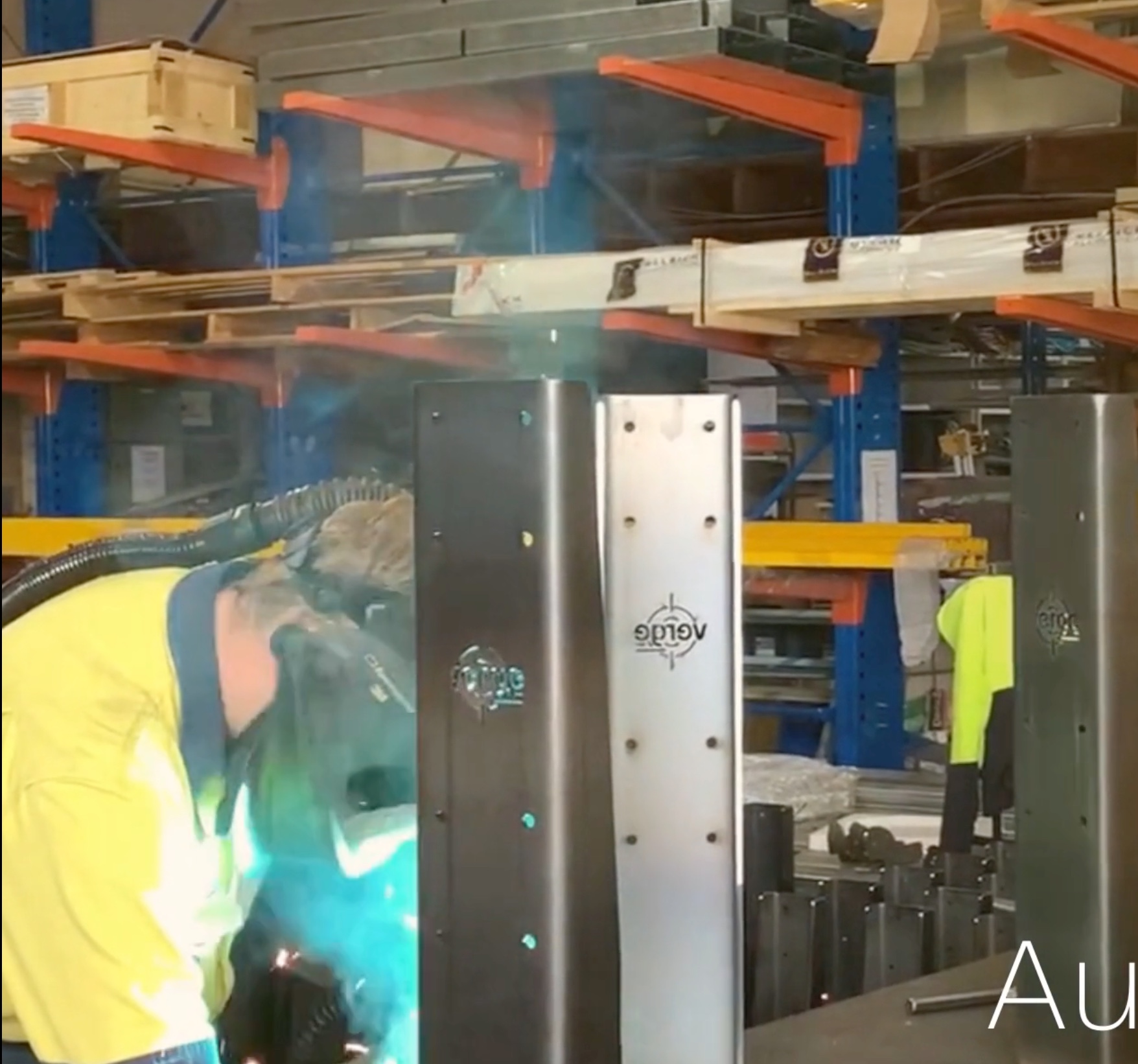 Welder working in a workshop, producing sparks.