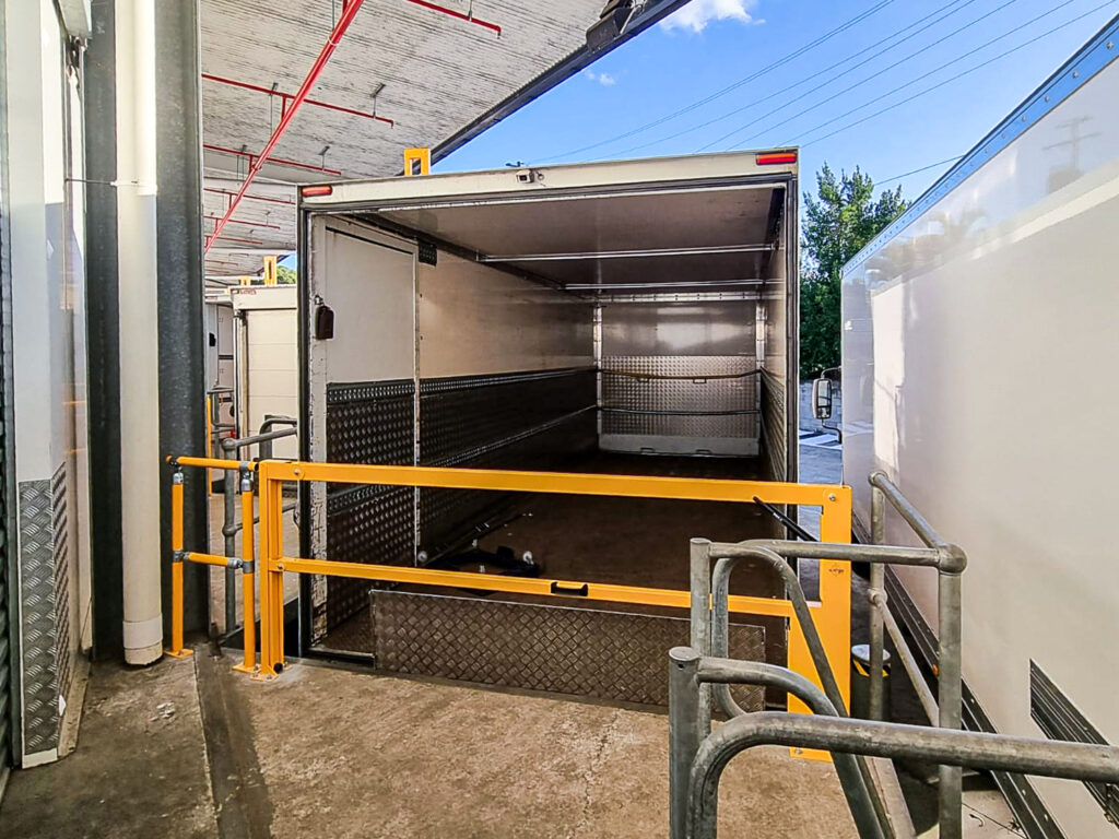 Open trailer with safety barriers at loading area