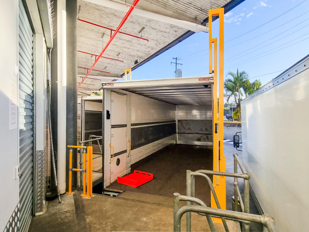 Loading dock with empty truck trailer displayed.