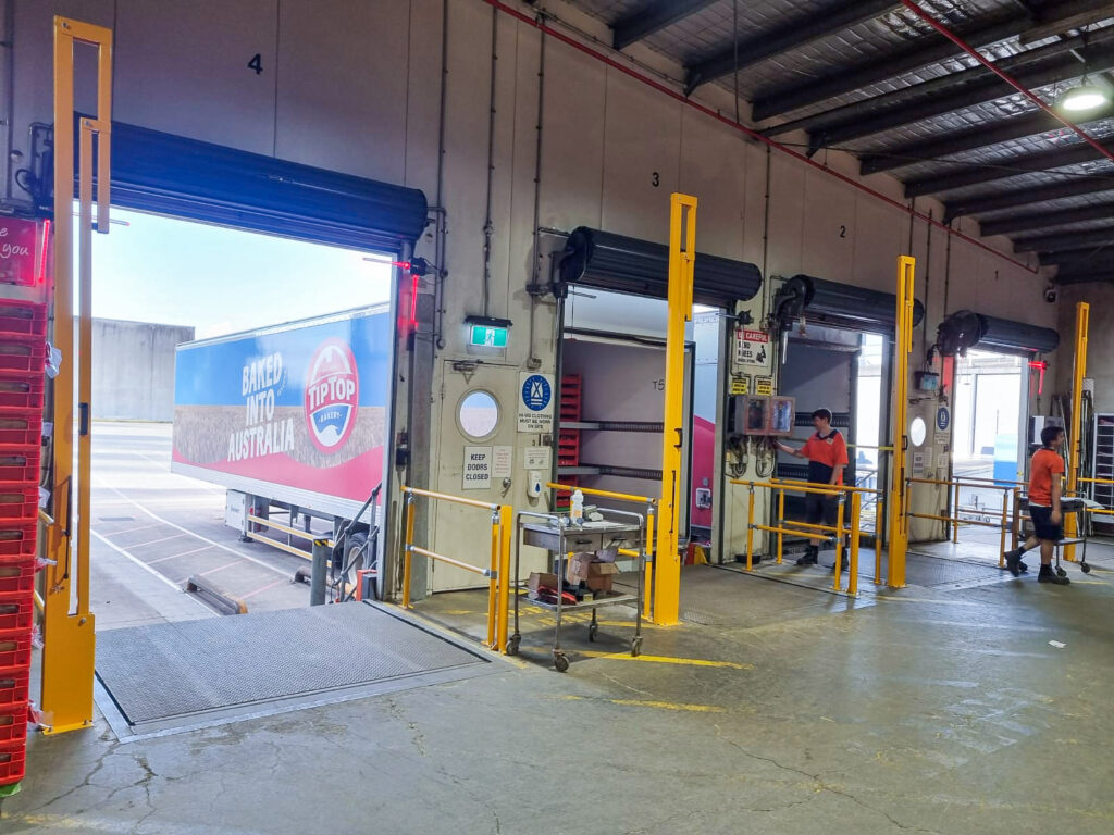 Warehouse loading dock with delivery truck and workers.