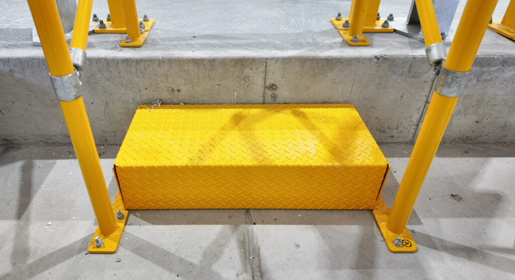 Yellow safety platform beside construction scaffolding.