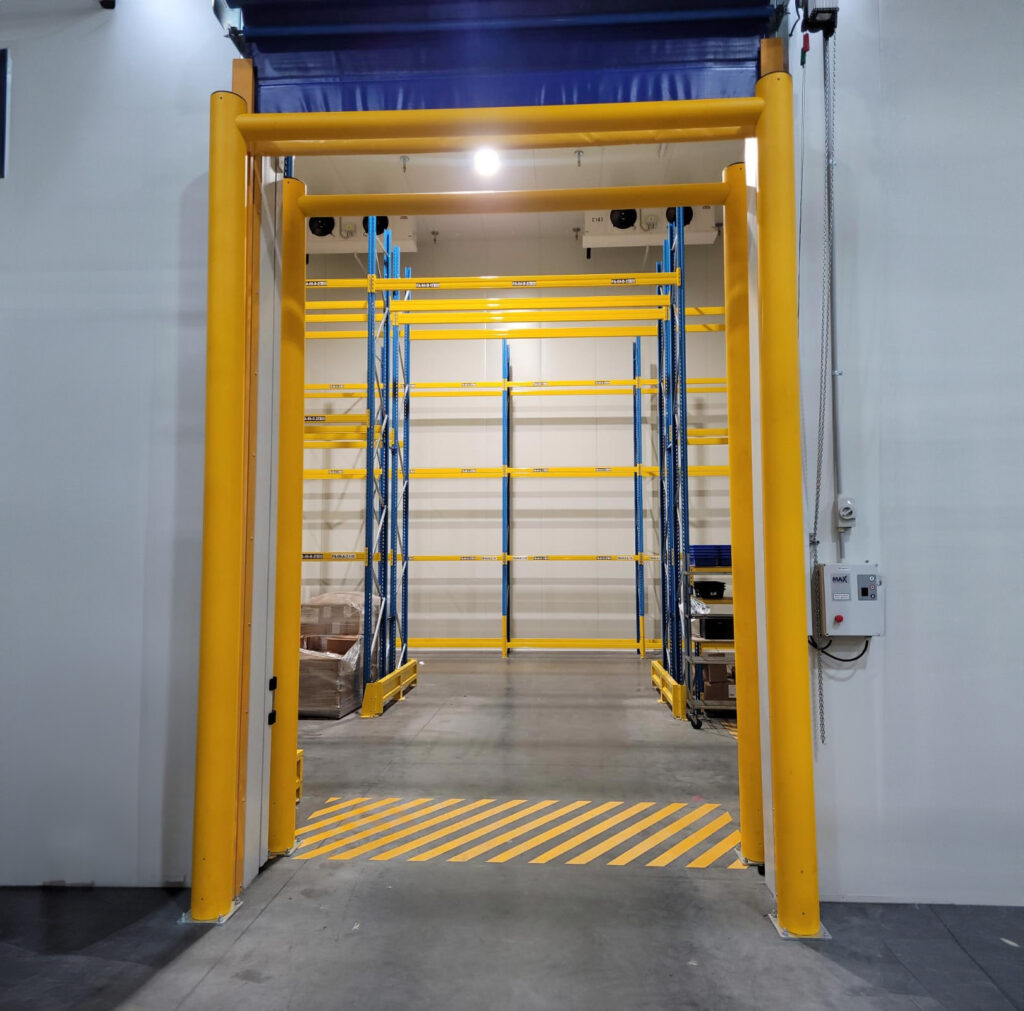 Warehouse entrance with yellow safety barriers and racking