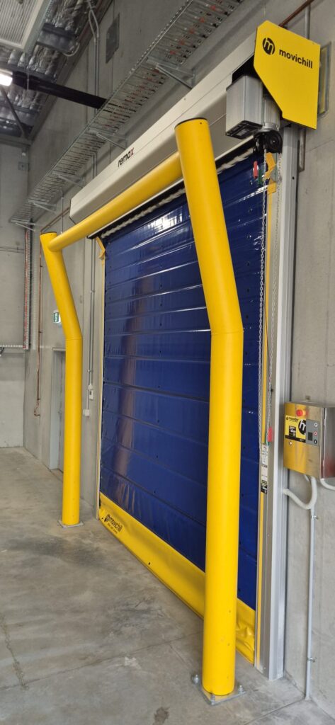 Industrial blue roller door with yellow safety bollards
