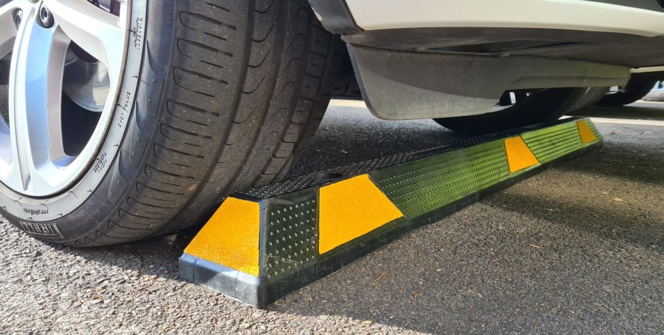 Car tire resting on a parking curb.
